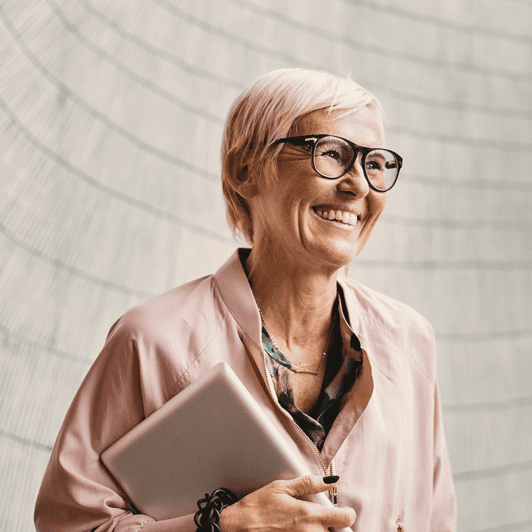 Woman smiling, holding notepad