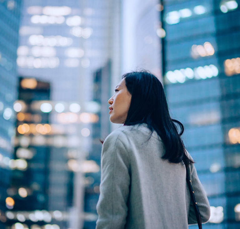 Profile of women looking to her left, set against cityscape background