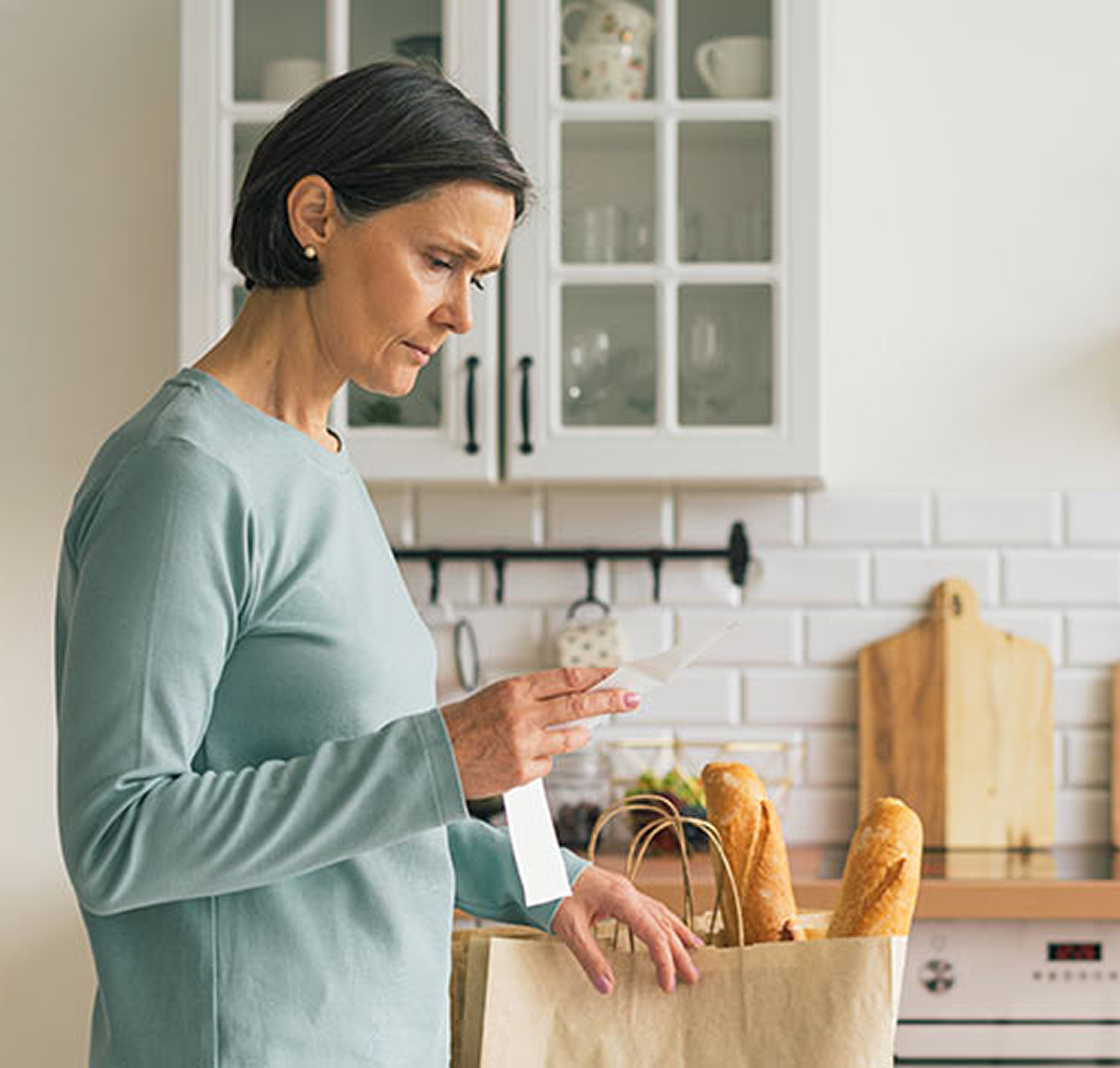 Woman with groceries in kitchen