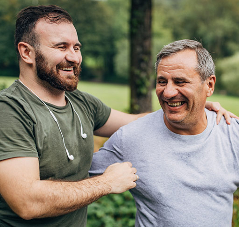 Father and son walking together through park