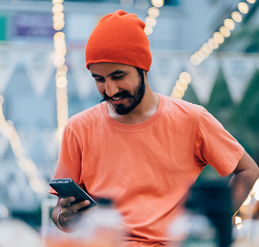 Man smiling while holding phone