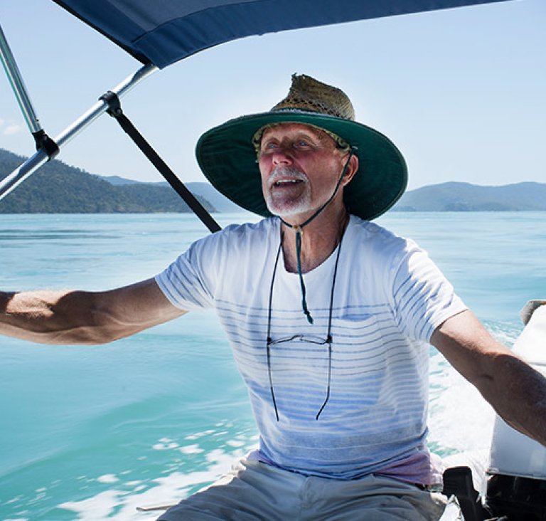 Man sitting on boat that is sailing across lake