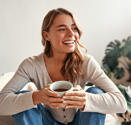 Woman smiling sitting and holding cup of coffee