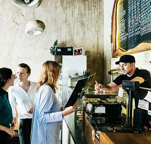 People lined up and ordering at cafe counter