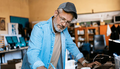 Man working behind desk, writing on paper