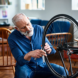 Person repairing a bicycle wheel indoors with tools.