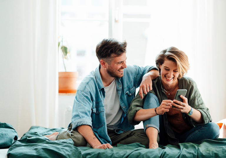 Man and woman sitting on bed