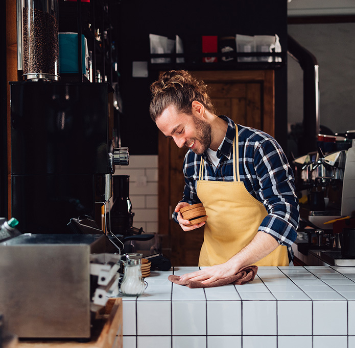 Man wiping down counter at cafe