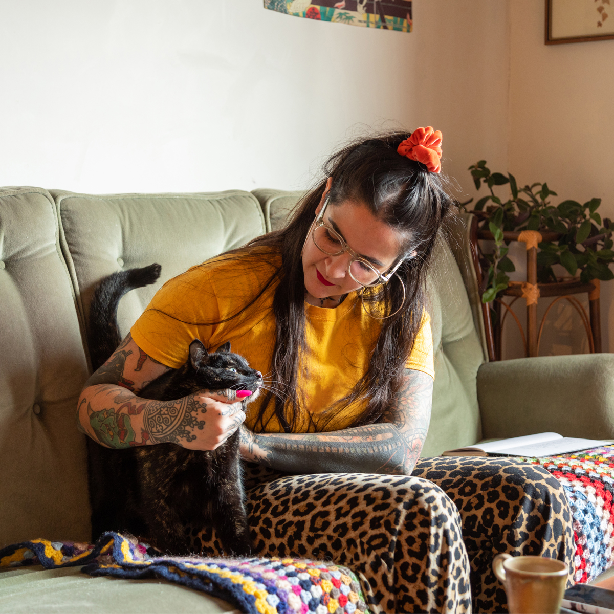lady sitting with her cat on a green couch