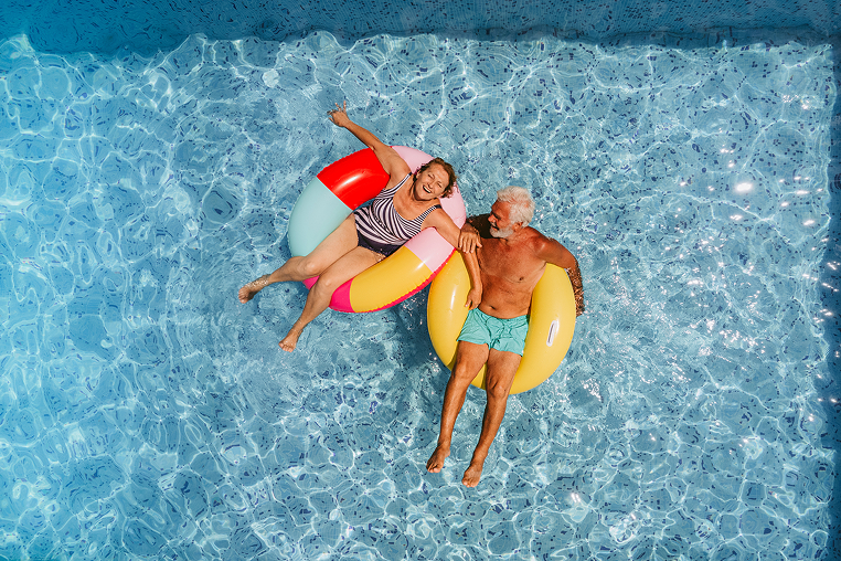 Older couple floating in pool