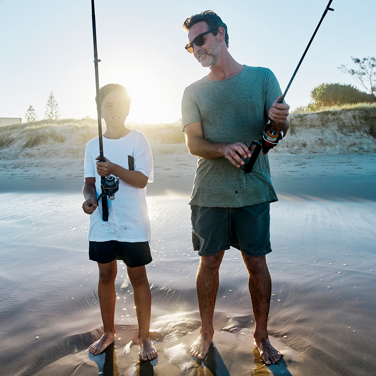 Father and son fishing on beach