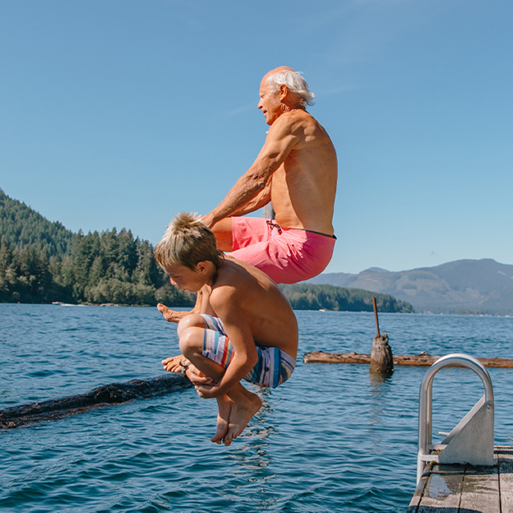 Man and child jumping into lake