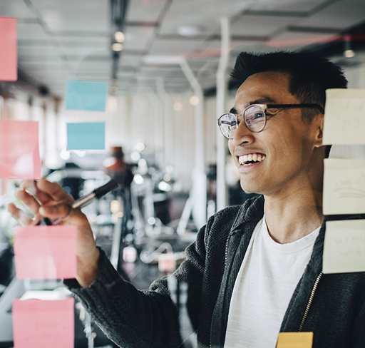 a man writing on a glass board