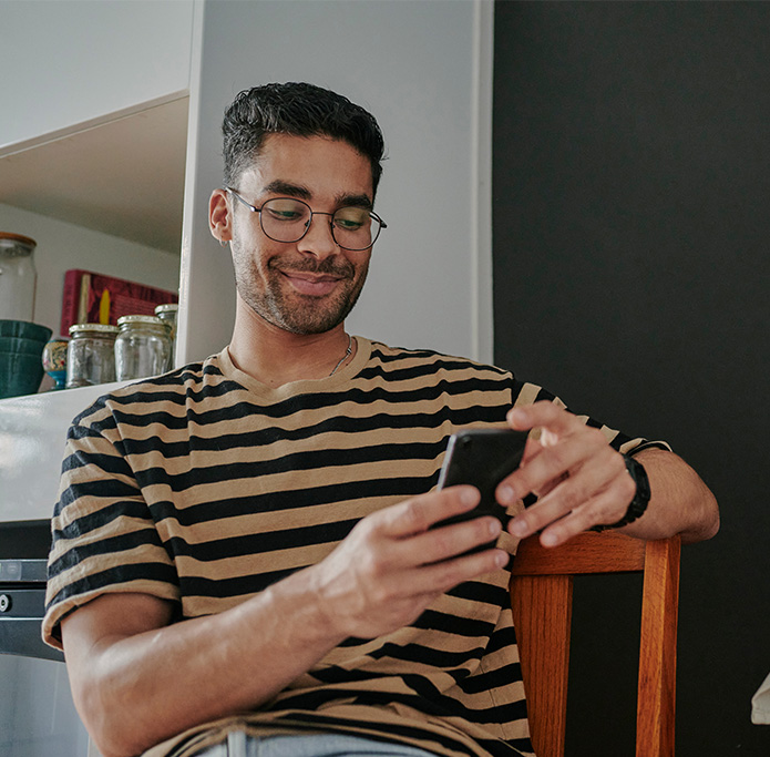 Man sitting on chair looking at his phone