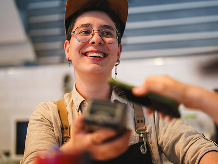Person smiling holding eftpos machine