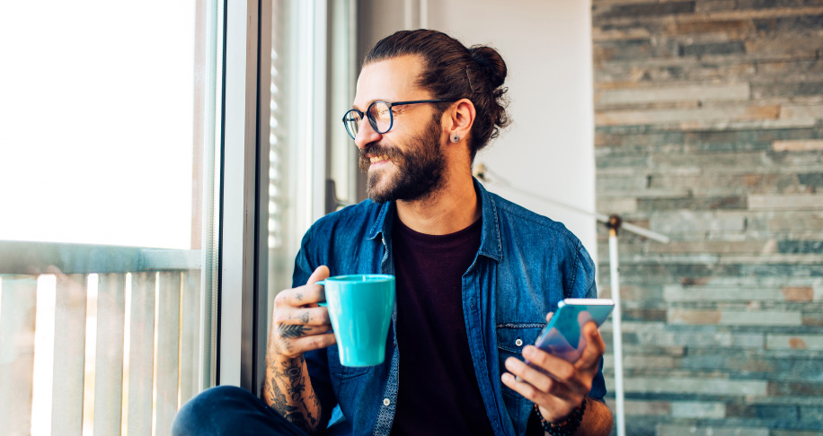 Person holding cup with mobile