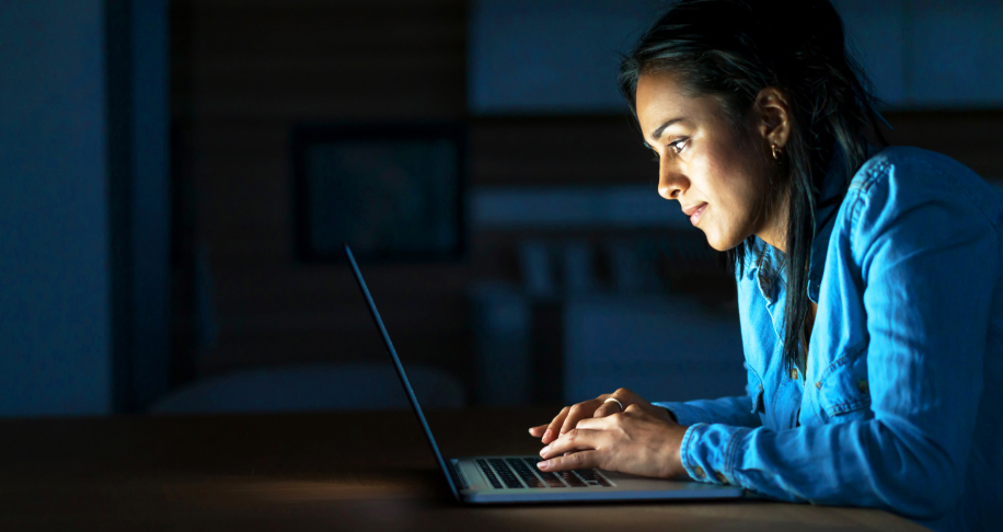 woman looking at laptop in the dark
