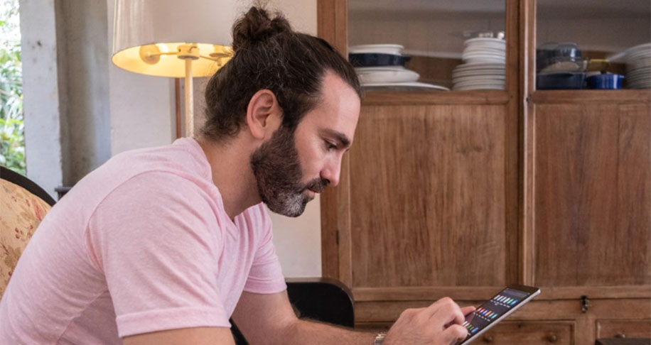 Man with hair bun on tablet