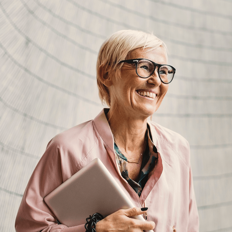 Woman smiling, holding notepad