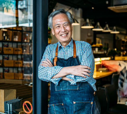 Store owner leaning against door to store